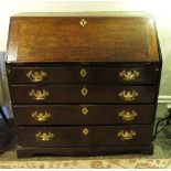 A late Georgian oak bureau, the fall flap fitted with pigeon holes and drawers,