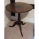 A small oak occasional table, the circular top raised on a tripod base,