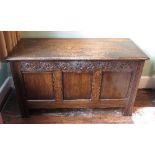 An oak coffer, the plain rising lid with plain panels,