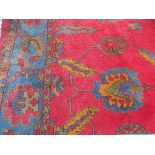 A large Turkish carpet, the red ground field with repeating motifs,