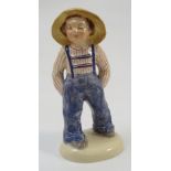 A Wedgwood & Co Ltd porcelain figure, of a boy wearing blue dungarees and a yellow hat,