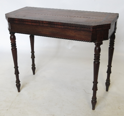 An early 19th century mahogany and rosewood fold over tea table, having cut brass inlay,