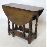 An oval oak gate leg table, raised on bobbin turned legs,