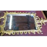 A George III style gilt framed wall mirror, decorated in the rococo style with leaves and scrolls,