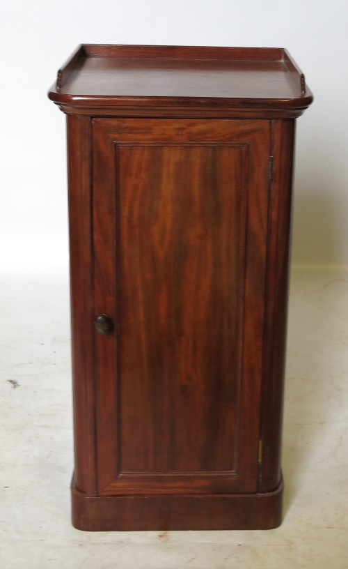 A 19th century mahogany pot cupboard, with fielded panelled door below the tray top,