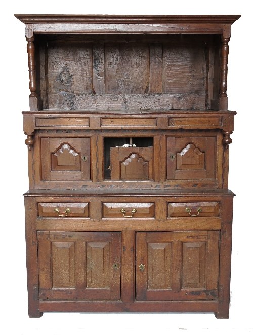 An Antique oak tridarn, having panelled canopy top, fitted two cupboard doors below,
