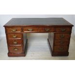 An Edwardian oak pedestal desk, fitted three frieze drawers below the leather inset top,