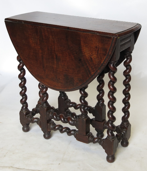 An 18th century style oak gate leg table, raised on spirally turned legs, with gate leg action,