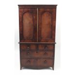 A 19th century miniature mahogany linen press, with two arched panel doors,