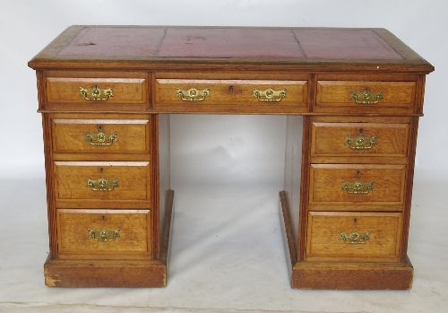 A late Edwardian oak pedestal desk, fitted with three short drawers to the frieze,