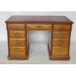 A late Edwardian oak pedestal desk, fitted with three short drawers to the frieze,