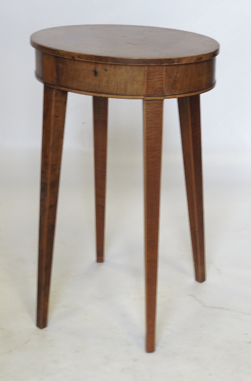 An oval mahogany work table, the rising lid revealing shallow interior,