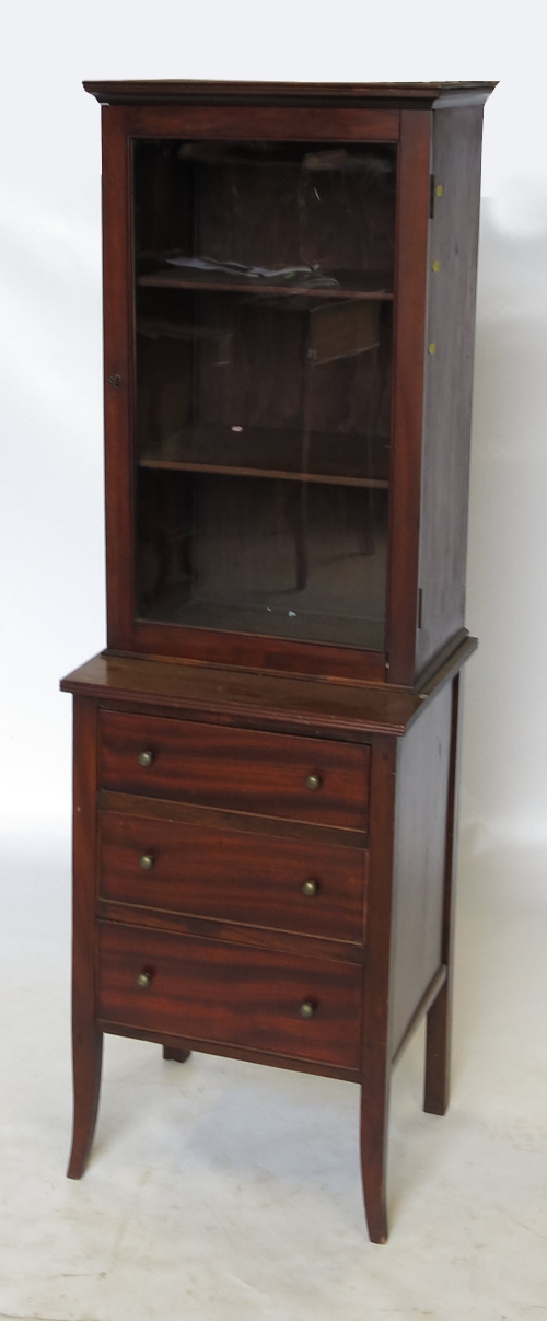 A 19th century mahogany cupboard, the glazed door opening to reveal shelves,