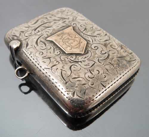 A silver and 9ct gold vesta case, Birmingham 1903, engraved with leaf scrolls,