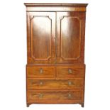 A late Georgian mahogany linen press, having two satinwood cross banded panels to the upper section,