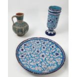 An Isnik style earthenware pottery charger, decorated with flowers and leaves to a blue ground,