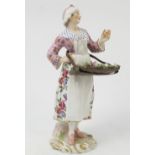 A 19th century Continental porcelain figure, of a woman carrying a tray of flowers,