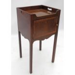 A mahogany bedside cabinet, of square form, with gallery edge and cut out handles, over a cupboard,