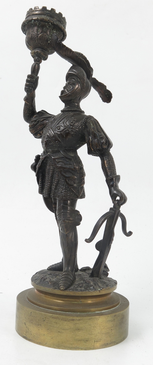 A 19th century bronzed candlestick, formed as a soldier in armour holding the sconce,