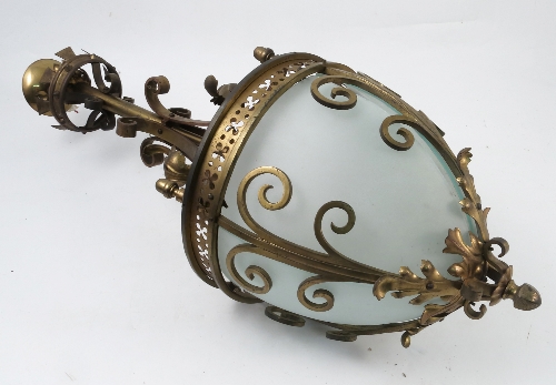 A brass hanging light fitting, the column decorated with plain scrolls and scrolling leaves,