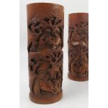 A pair of Oriental carved bamboo vases, of cylindrical form, decorated with figures,