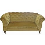 A two seat Chesterfield sofa, having deep button back and arms, with drop end,