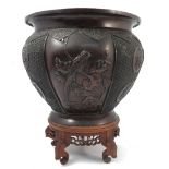 An Eastern bronze jardiniere, of lobbed circular form, embossed with birds, flowers and symbols,