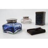 A pair of squat glass inkwells, with silver plated covers,