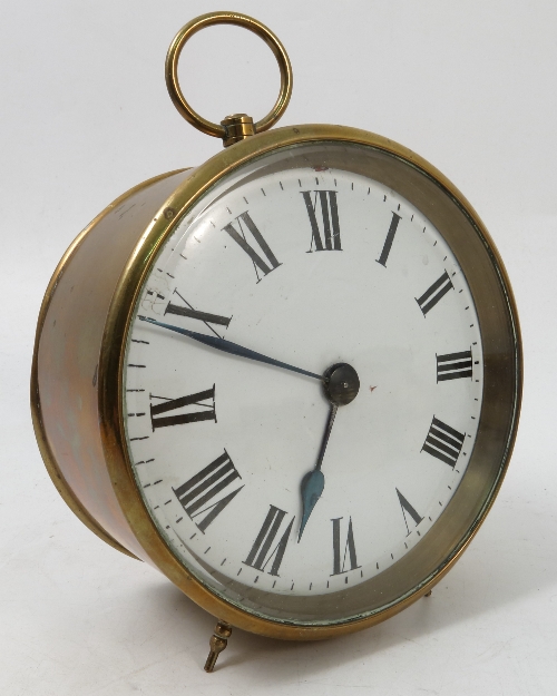 A circular brass cased clock, the white enamel dial with Roman numerals with circular case,
