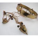 A brass weighted light fitting, the circular band decorated with lion masks,