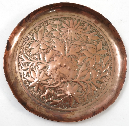 A Keswick School of Industrial Arts copper circular dish, embossed with flowers and leaves,