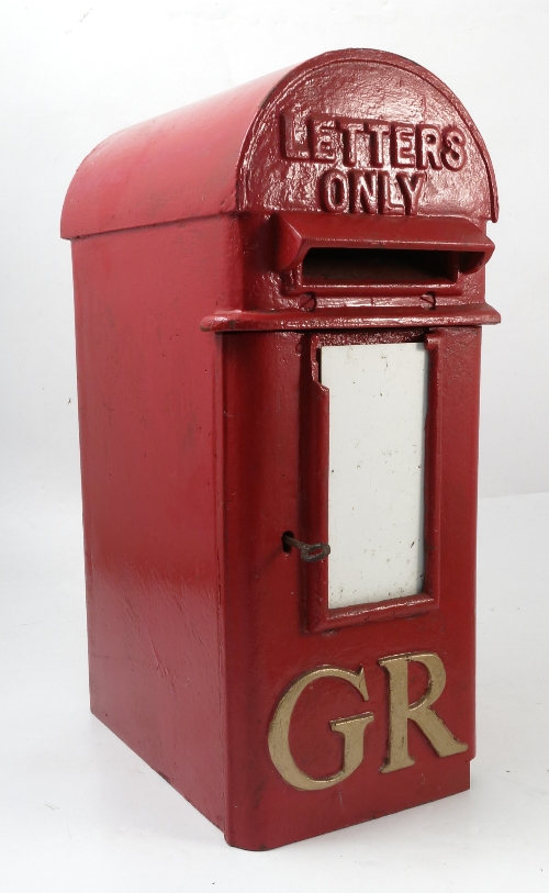 A red letter box, with arched top and gold GR,