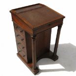 An early 19th century rosewood Davenport, with rising lid fitted with a short stationery drawer,