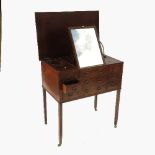 A late mahogany Georgian dressing table, with rising lid revealing a ratcheted mirror,