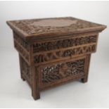 A mahogany carved table, heavily carved to the top and base with dragons and Oriental symbols,