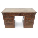 A late 19th century carved oak desk, fitted with two drawers to the carved frieze,