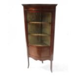 An Edwardian serpentine fronted mahogany corner cupboard,