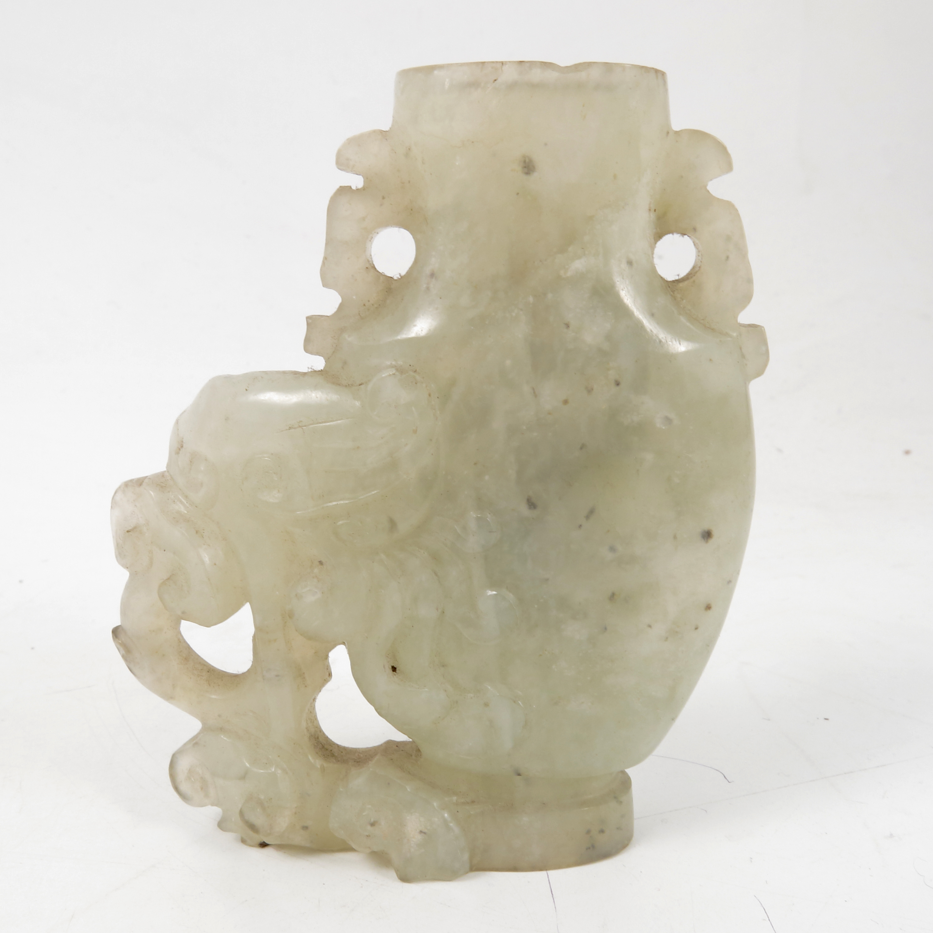 A carved hardstone vase, possibly white jade, of a stylized elephant and foliage, height 3.