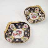 A pair of 19th century English porcelain dishes, of shaped form with integral gilt handle,