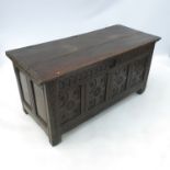 An antique oak coffer, having four carved pairs to the front below plain rising lid, width 53.