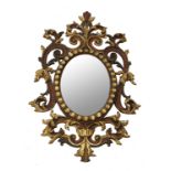 An ornate 18th century style oval mirror, with part gilded decoration,