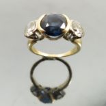 A Sapphire and diamond three stone ring, the round cut sapphire approximately 8.