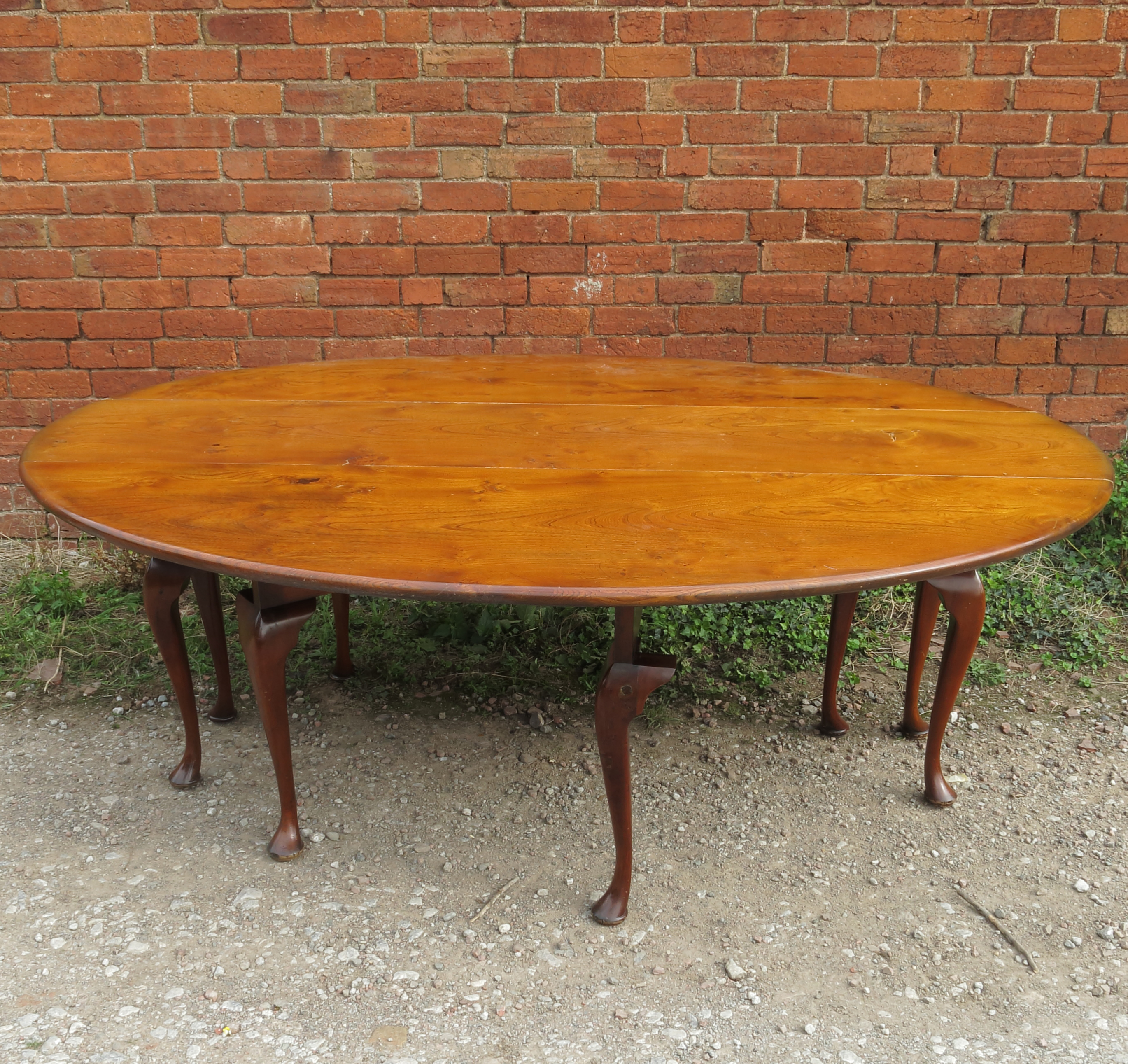 A large reproduction oval wake table, raised on eight cabriole legs,