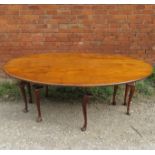 A large reproduction oval wake table, raised on eight cabriole legs,