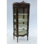 A continental style mirror backed vitrine, with serpentine glazed front and curved glazed sides,