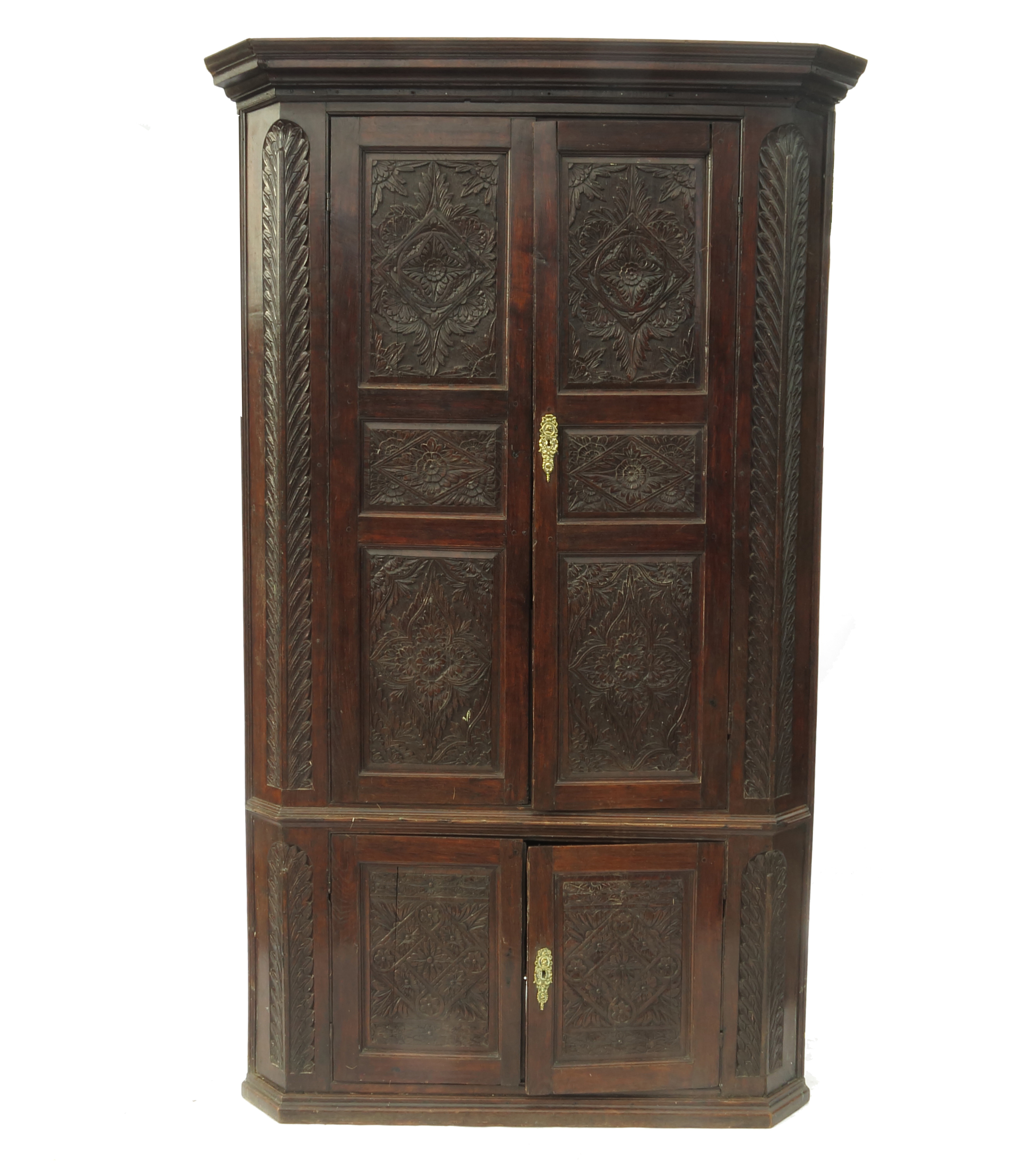 A large 19th century oak free standing corner cupboard, with carved panel doors,