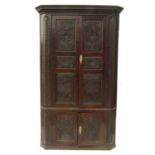 A large 19th century oak free standing corner cupboard, with carved panel doors,