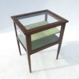 An Edwardian mahogany two tier bijouterie table, with glazed sides and top,
