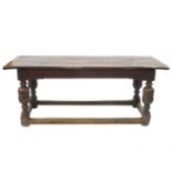 An antique oak refectory or serving table, having a three plank cleated top with a carved frieze,