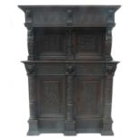 An antique oak cupboard, with canopy top over two doors flanked by columns,